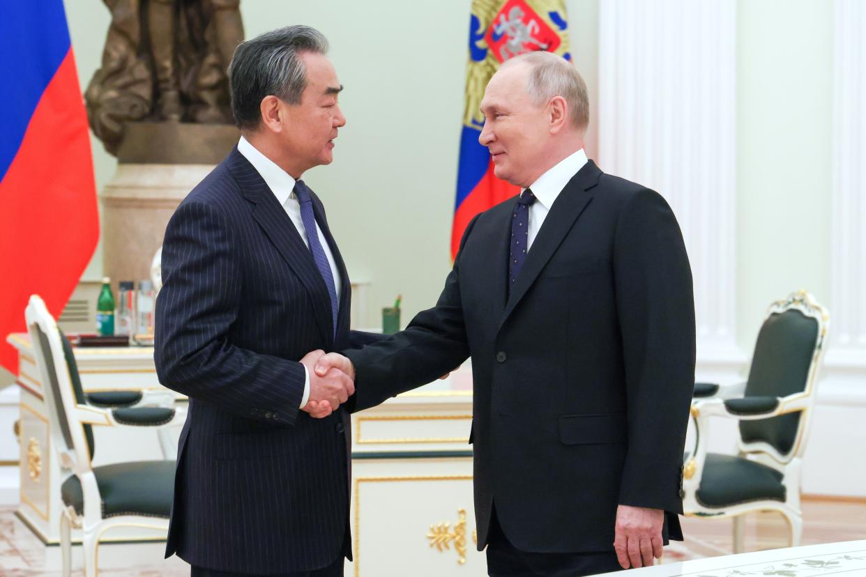 Russian President Vladimir Putin greets Chinese Communist Party's foreign policy chief Wang Yi during their meeting at the Kremlin in Moscow, Russia, Wednesday, Feb. 22, 2023. (Anton Novoderezhkin, Sputnik, Kremlin Pool Photo via AP)