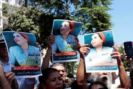 FILE PHOTO: Moroccan activists hold posters of Hajar Raissouni, a journalist charged with fornication and abortion, during a protest outside the Rabat tribunal