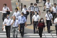 People wearing face masks to help protect against the spread of the new coronavirus pass on a crosswalk on a street in Tokyo, Tuesday, Aug, 4, 2020. (AP Photo/Koji Sasahara)