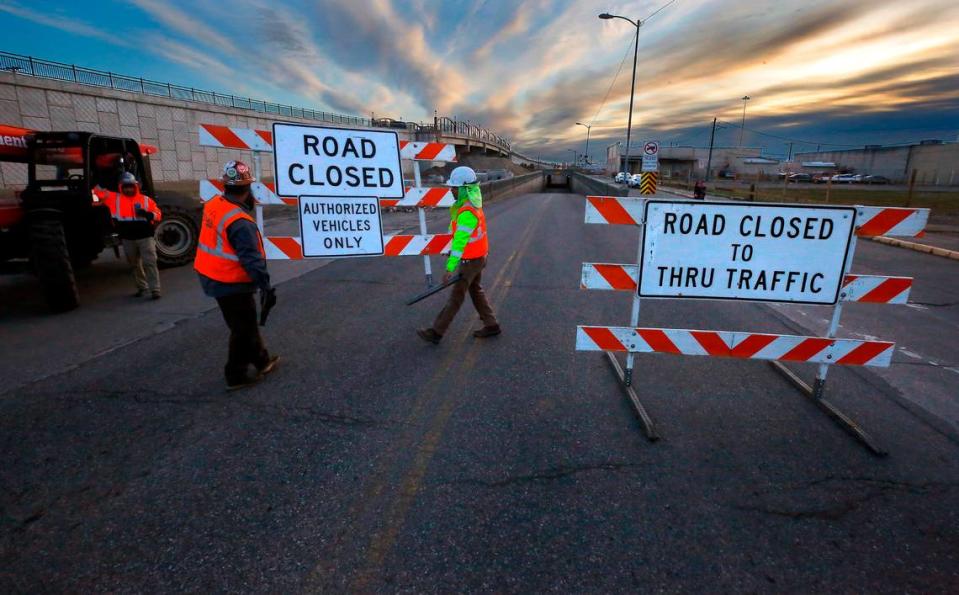 Construction workers block off the west end roadway of the Lewis Street underpass early Monday as the first step in preparing to demolish the historic underground structure.