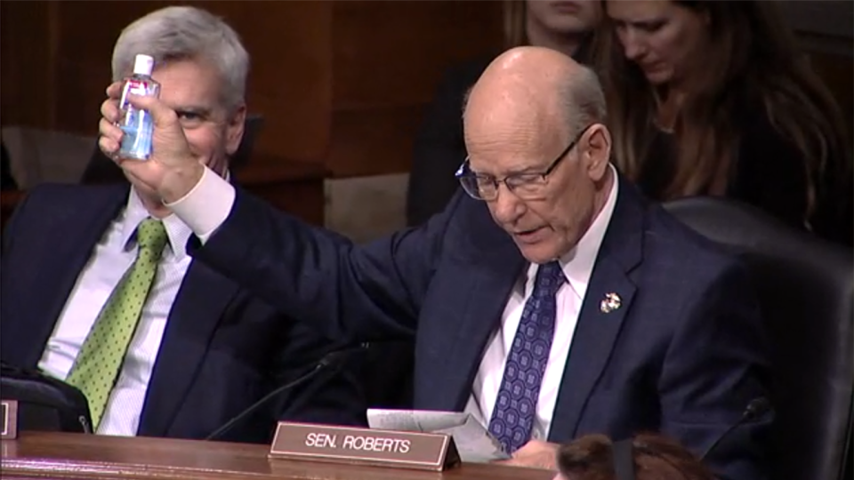 Sen. Pat Roberts hold up a bottle of Purell hand sanitizer while Sen. Bill Cassidy looks on during a Senate Health, Education, Labor and Pensions Committee Hearing on the coronavirus on Capitol Hill, Tuesday, March 3, 2020, in Washington. (Screengrab via Senate TV)