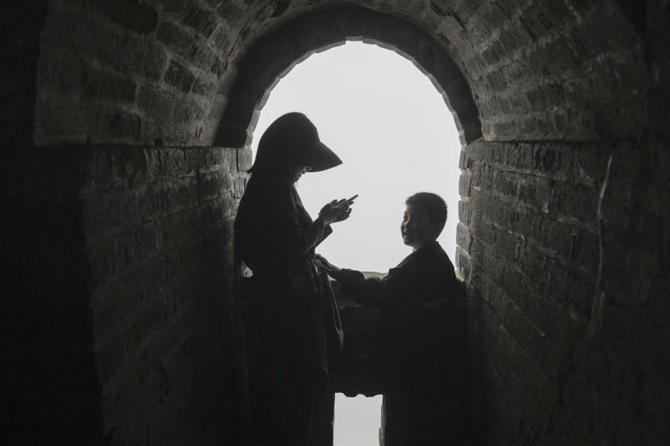 A woman and child stand at a tower window of the Badaling section of the Great Wall of China on the outskirts of Beijing, Saturday, April 13, 2024. (AP Photo/Tatan Syuflana)