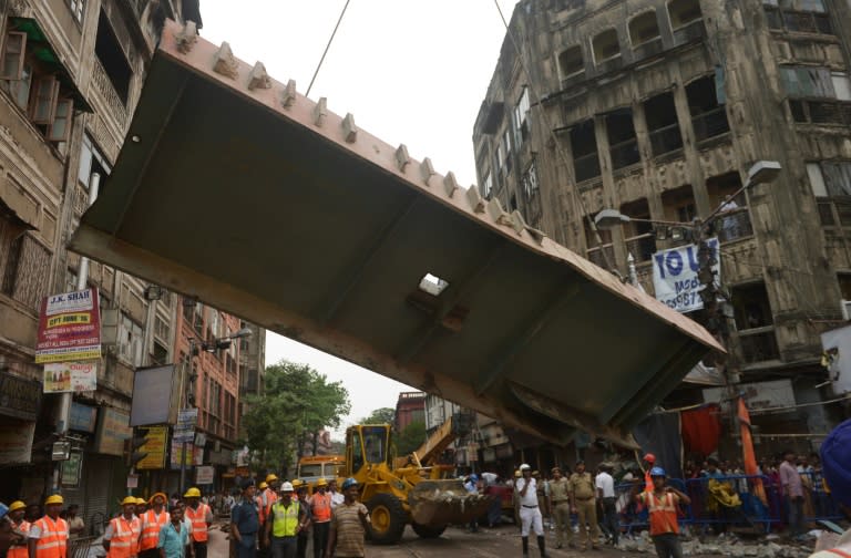 Rescue workers try to free people trapped under the wreckage of a collapsed flyover bridge in Kolkata, eastern India on April 1, 2016