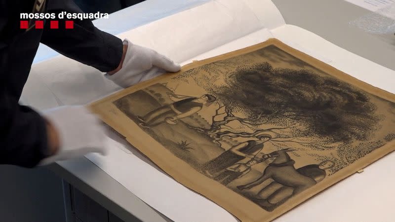 Un Mosso d'Esquadra manipula un dibujo a carboncillo recuperado del artista español Salvador Dalí que había sido robado en Barcelona, Cataluña, España