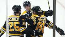 Boston Bruins right wing David Pastrnak (88) is congratulated by Brandon Carlo (25) and Patrice Bergeron, center, after his goal against the Washington Capitals during the third period of an NHL hockey game, Wednesday, March 3, 2021, in Boston. (AP Photo/Charles Krupa)