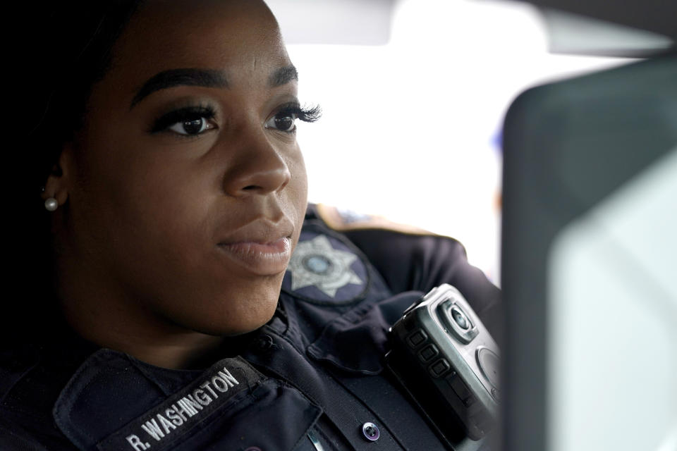 In this April 17, 2020, photo Harris County Sheriff's Deputy Ravin Washington logs onto her computer inside her patrol car before starting her patrol in Spring, Texas. Washington tested positive for COVID-19 in mid-March and returned to patrol on April 15 after recovering at home. (AP Photo/David J. Phillip)