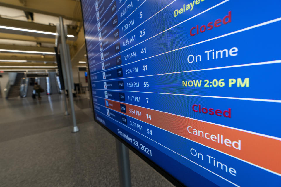 A flight shows cancelled on the departures board at Ronald Reagan Washington National Airport, Wednesday, Dec. 29, 2021, in Arlington, Va. Winter weather and crew members infected with COVID-19 have forced airlines to spike thousands of U.S. flights over the past week, complicating travel plans for many people during the busy holiday season. It’s not clear when travel will return to normal, but airlines say a recent move by U.S. public health officials should help get workers back sooner. (AP Photo/Alex Brandon)