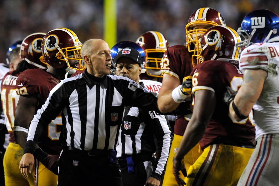 Referee Terry McAulay #77 holds back a Washington Redskins player in the third quarter after a Alfred Morris #46 of the Washington Redskins fumble against the New York Giants at FedExField on December 3, 2012 in Landover, Maryland. (Photo by Patrick McDermott/Getty Images)