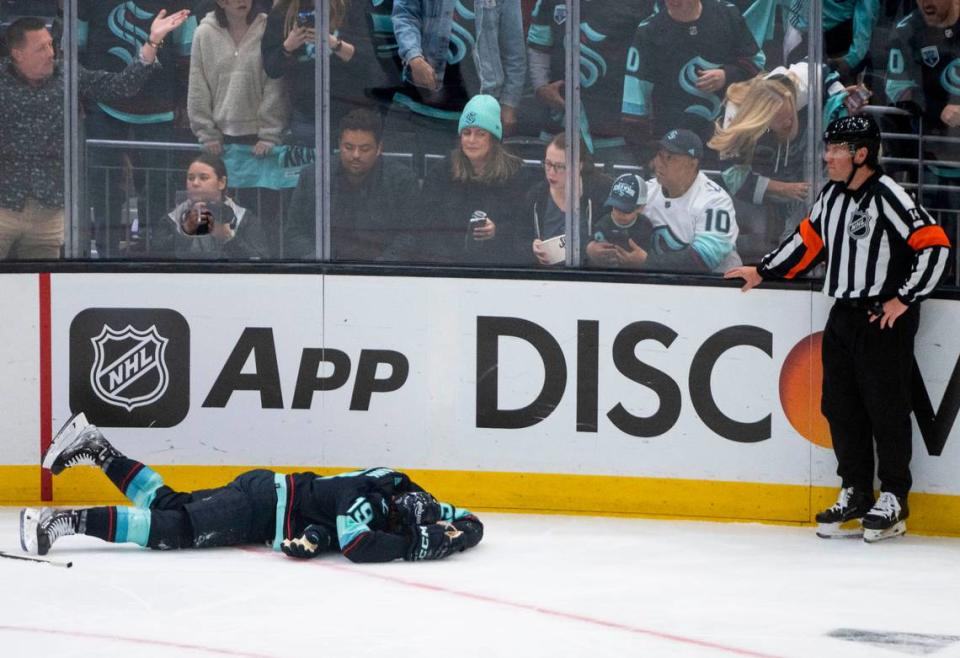 Seattle Kraken left wing Jared McCann (19) lies on the ice after being injured by Colorado Avalanche defenseman Cale Makar (8) during the first period of a first round 2023 Stanley Cup Playoffs game against the Colorado Avalanches at Climate Pledge Arena in Seattle on Monday, April 24, 2023.