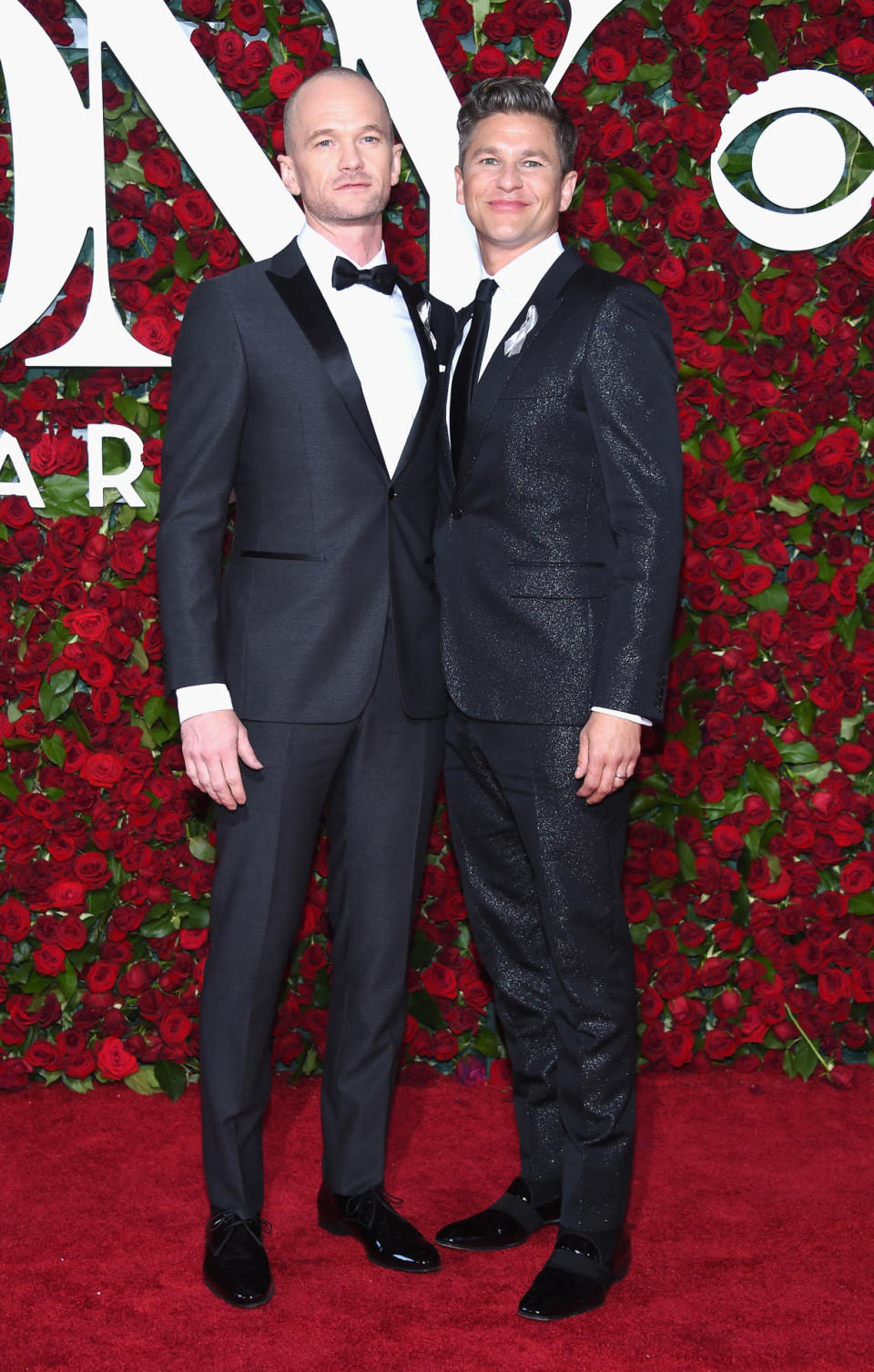 Neil Patrick Harris, showing off a freshly shaved head and wearing Ermenegildo Zegna, with husband David Burtka 