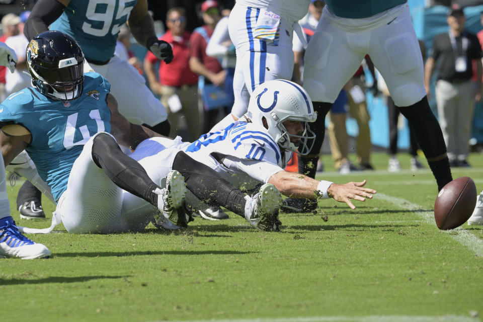 Indianapolis Colts quarterback Gardner Minshew (10) reaches for his fumble after being sacked by Jacksonville Jaguars linebacker Josh Allen (41) during the first half of an NFL football game, Sunday, Oct. 15, 2023, in Jacksonville, Fla. (AP Photo/Phelan M. Ebenhack)