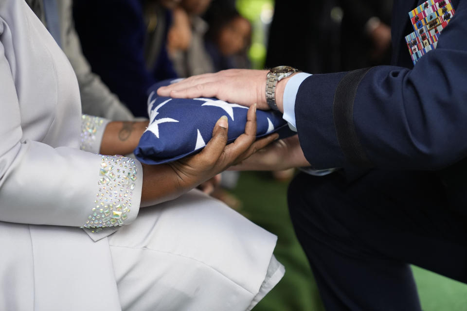 Chantemekki Fortson the mother of slain airman Roger Fortson, left, receives the U.S. burial flag during the interment for Fortson at Lincoln Memorial Cemetery, Friday, May 17, 2024, in Atlanta. (AP Photo/Brynn Anderson)