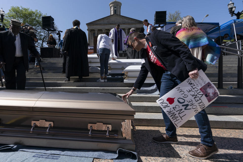 Jason Sparks touches a casket outside the state Capitol during a Tennessee Moral Monday rally to protest gun violence in Nashville, Tenn., Monday, April 17, 2023. (AP Photo/George Walker IV)