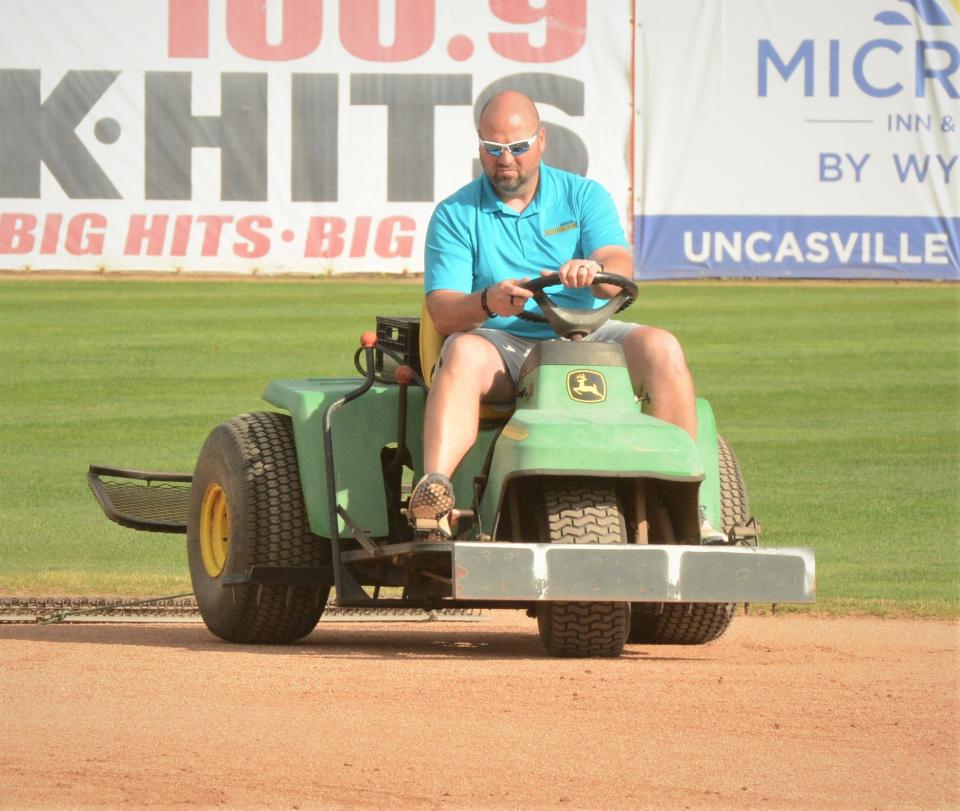 Norwich Sea Unicorns General Manager Lee Walter, Jr. rakes the infield before Wednesday's game against Nashua at Dodd Stadium.
