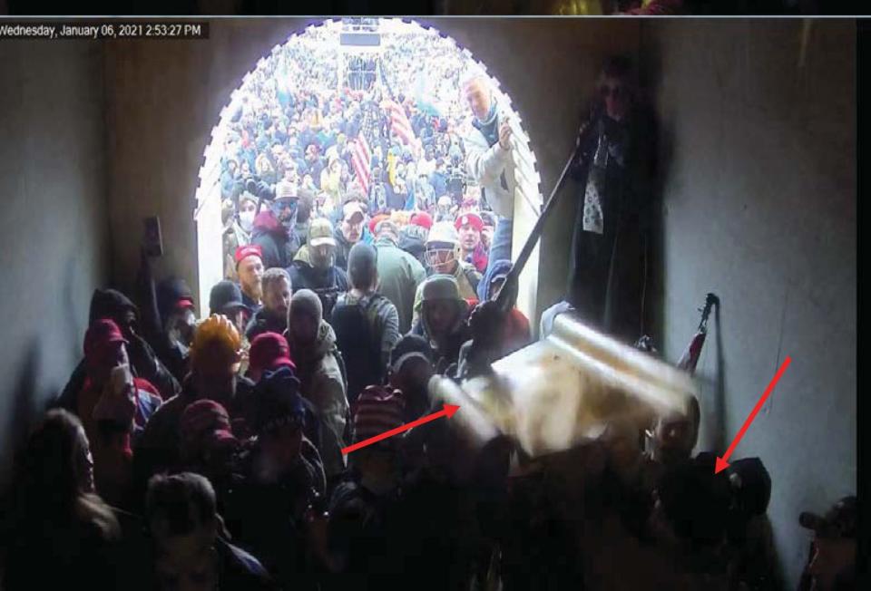 Protesters are shown pressed into a U.S. Capitol entrance in this image of the Jan. 6, 2021 riot. Arrows on the image were placed by authorities to show a plastic shield like those used by police being passed through a crowd.