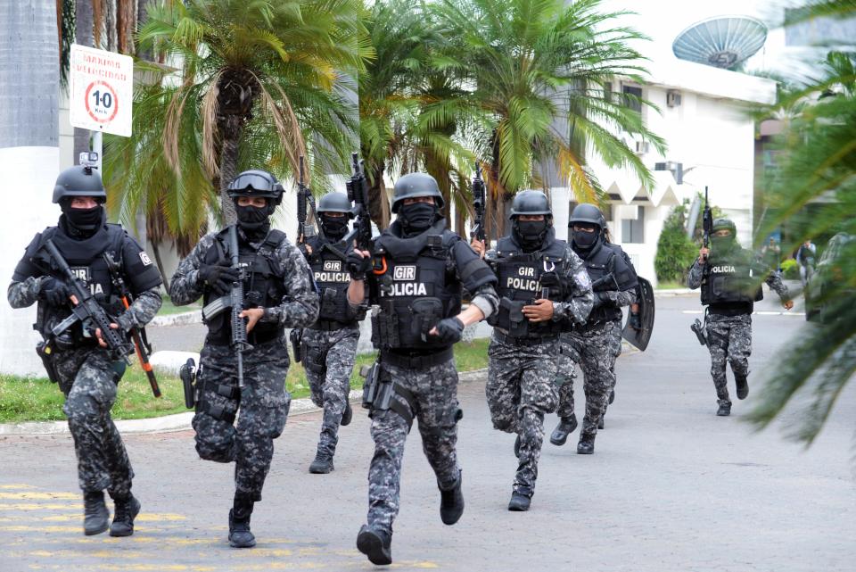  An Ecuadorean police squad enters the premises of Ecuador's TC television channel after unidentified gunmen burst into the state-owned television studio live on air. / Credit: STRINGER/AFP via Getty Images