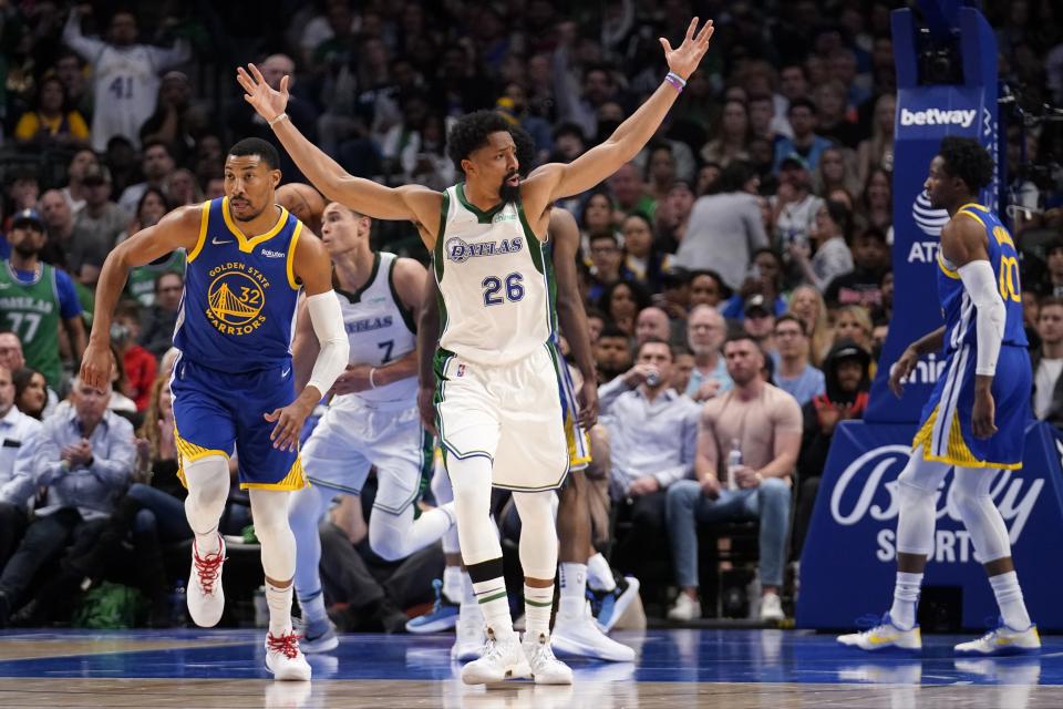 Dallas Mavericks guard Spencer Dinwiddie (26) looks for a foul call after sinking a basket as Golden State Warriors' Otto Porter Jr. (32) follows behind in the second half of an NBA basketball game in Dallas, Thursday, March, 3, 2022. (AP Photo/Tony Gutierrez)