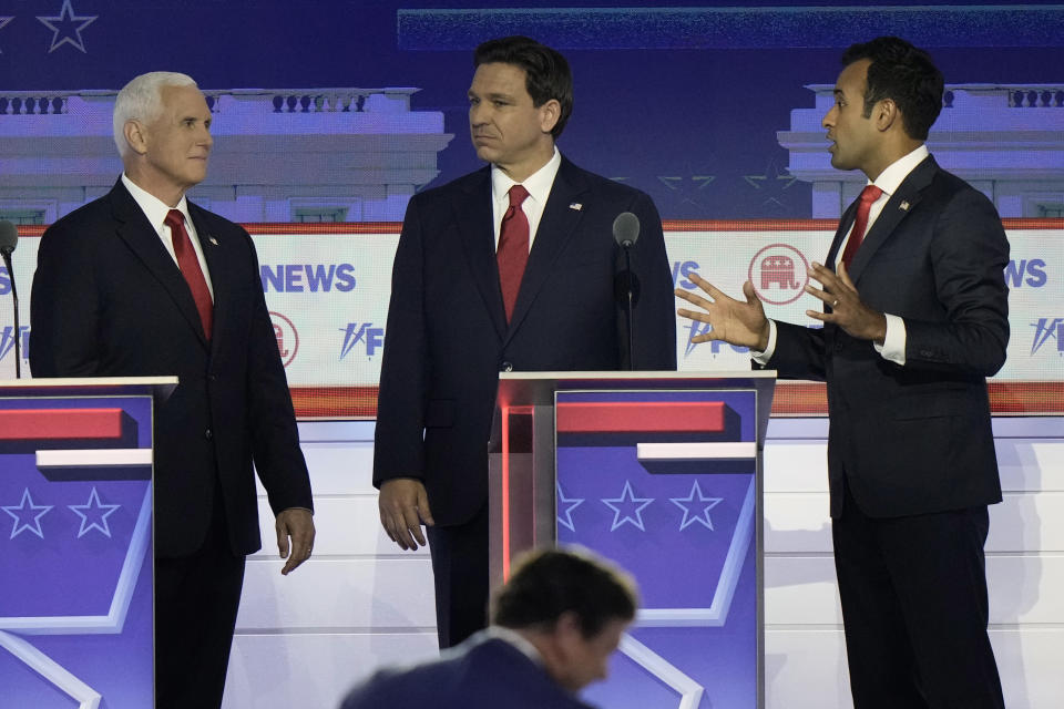 Former Vice President Mike Pence and Florida Gov. Ron DeSantis listen as businessman Vivek Ramaswamy speaks during break in a Republican presidential primary debate hosted by FOX News Channel Wednesday, Aug. 23, 2023, in Milwaukee. (AP Photo/Morry Gash)