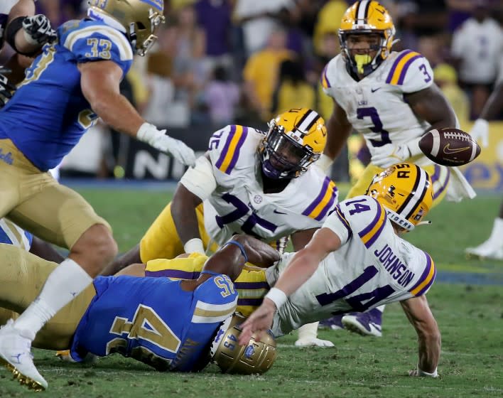 UCLA linebacker Mitchell Agude (45) knocks the ball loose from LSU quarterback Max Johnson on Sept. 4, 2021.