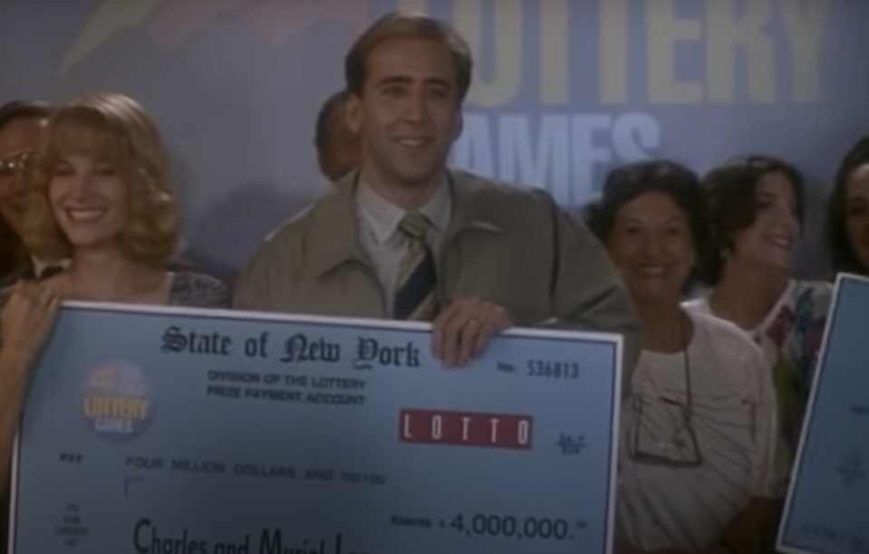 Nic Cage and Bridget Fonda holding a giant check in "It Could Happen to You"