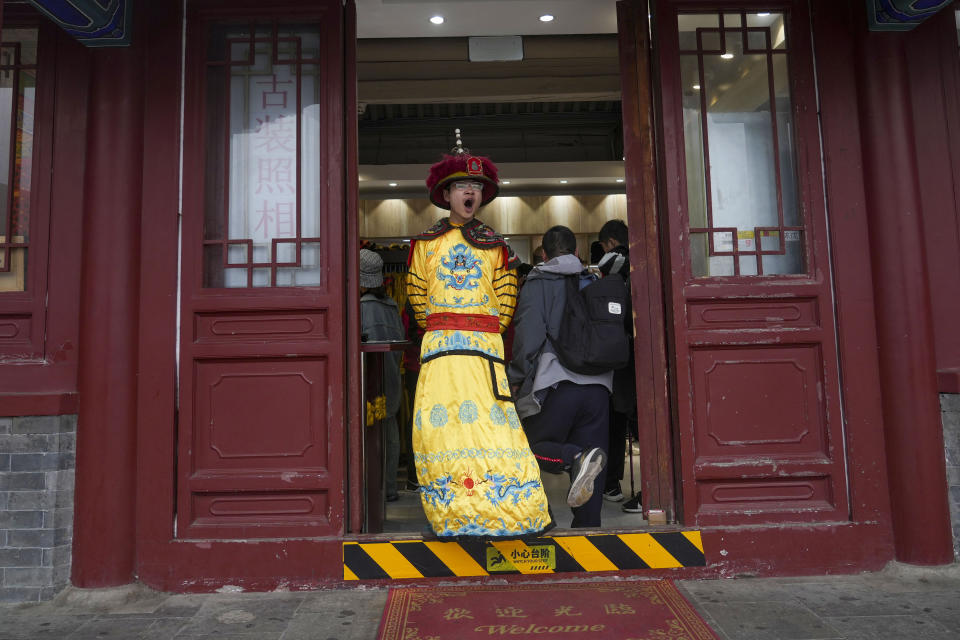 A man dressed in imperial costume depicting the emperor stands at a souvenir store near Great Wall of China on the outskirts of Beijing, Saturday, April 13, 2024. (AP Photo/Tatan Syuflana)