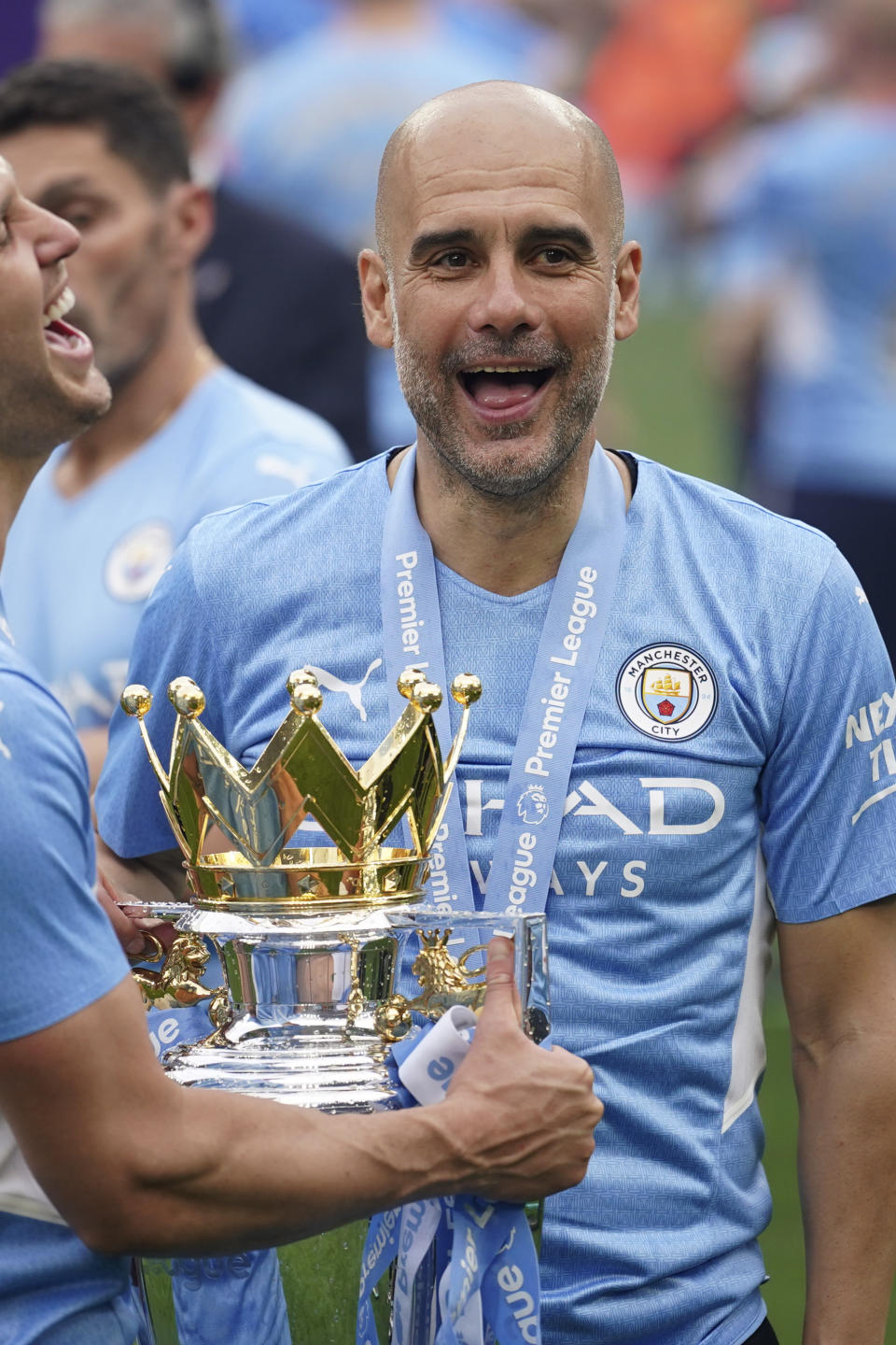 Manchester City's head coach Pep Guardiola, right, smiles with trophy after winning the 2022 English Premier League title at the Etihad Stadium in Manchester, England, Sunday, May 22, 2022. (AP Photo/Dave Thompson)