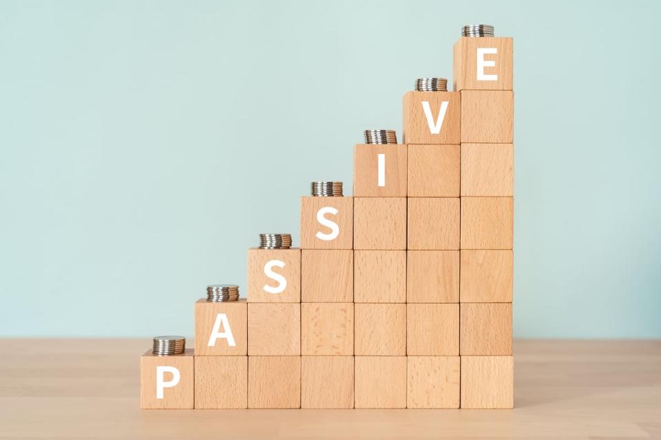 Wooden blocks on a table with the word "PASSIVE" written on blocks in an ascending step pattern up and to the right.