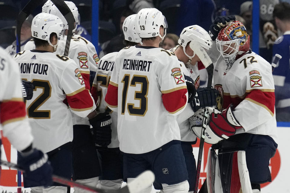 Florida Panthers goaltender Sergei Bobrovsky (72) celebrates with teammates, including center Sam Reinhart (13) and defenseman Brandon Montour (62) after the team defeated the Tampa Bay Lightning during the third period of an NHL hockey game Wednesday, Dec. 27, 2023, in Tampa, Fla. (AP Photo/Chris O'Meara)