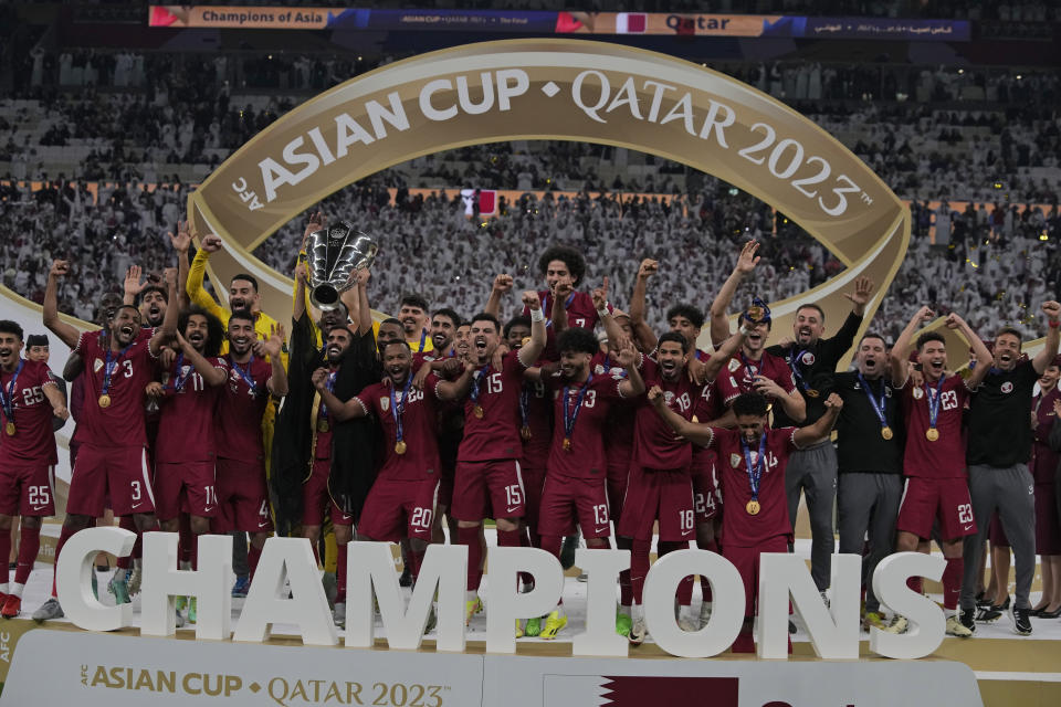 Team Qatar poses with the winning trophy at the end of the Asian Cup final soccer match between Qatar and Jordan at the Lusail Stadium in Lusail, Qatar, Saturday, Feb. 10, 2024. (AP Photo/Thanassis Stavrakis)