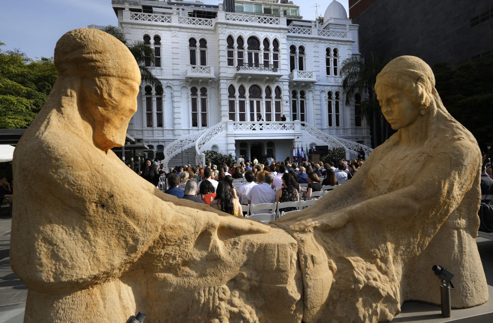 People gather in front of two sculptures at the courtyard of the Sursock Museum during an opening event for the iconic venue in Beirut, Lebanon, Friday, May 26, 2023. The museum has reopened to the public, three years after after a deadly explosion in the nearby Beirut port reduced many of its treasured paintings and collections to ashes. (AP Photo/Hussein Malla)