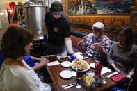 Tim Stevenson serves an appetizer to customers at San Pedro Brewing Company on Friday, May 29, 2020, in the San Pedro area of Los Angeles. (AP Photo/Ashley Landis)