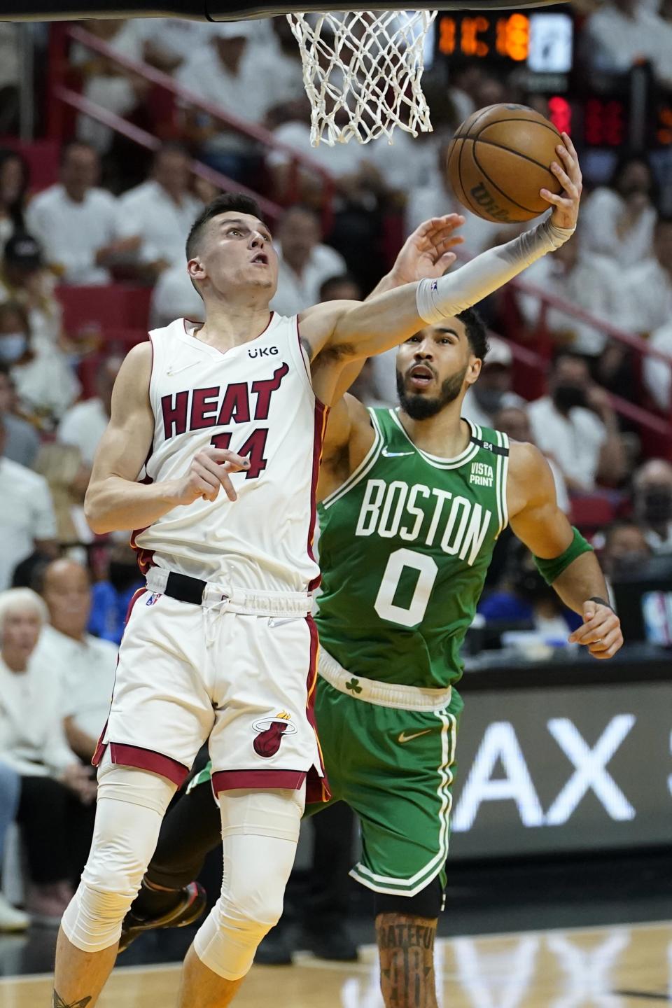 Miami Heat guard Tyler Herro (14) drives to the basket as Boston Celtics forward Jayson Tatum (0) defends during the first half of Game 2 of the NBA basketball Eastern Conference finals playoff series, Thursday, May 19, 2022, in Miami. (AP Photo/Lynne Sladky)