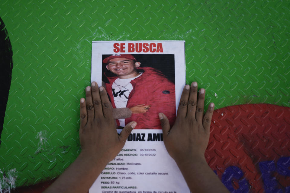 A woman pastes a portrait of a missing person on a roundabout barrier along Reforma Avenue during a march demanding the government do more to locate their loved ones, marking International Day of the Disappeared, in Mexico City, Wednesday, Aug. 30, 2023. Mothers of some of 111,000 people who have disappeared in Mexico over decades of violence, most believed to have been abducted by drug cartels or kidnapped by gangs, gathered on Wednesday on Reforma Avenue. (AP Photo/Eduardo Verdugo)