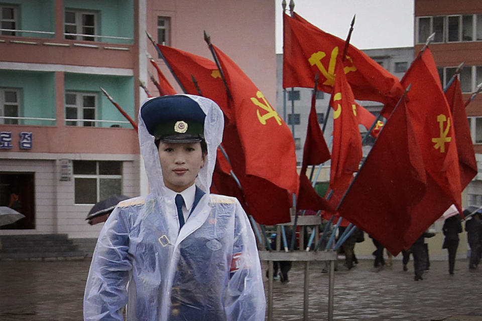 A North Korean traffic police woman directs vehicles at a street junction while behind her the sidewalk is decorated with flags of the ruling party, the Workers’ Party, May 5, 2016, in Pyongyang, North Korea. Members of North Korea’s ruling party have gathered in Pyongyang ahead of their biggest political conference in decades. Foreign experts say North Korea’s leader Kim Jong Un will likely use the meeting to place his loyalists into key positions, strengthen his push to upgrade his country’s nuclear arsenal and cement his grip on power. (Wong Maye-E/AP)