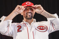 Cincinnati Reds' Nick Castellanos puts on his cap during a news conference, Tuesday, Jan. 28, 2020, in Cincinnati. Castellanos signed a $64 million, four-year deal with the baseball club. (AP Photo/John Minchillo)
