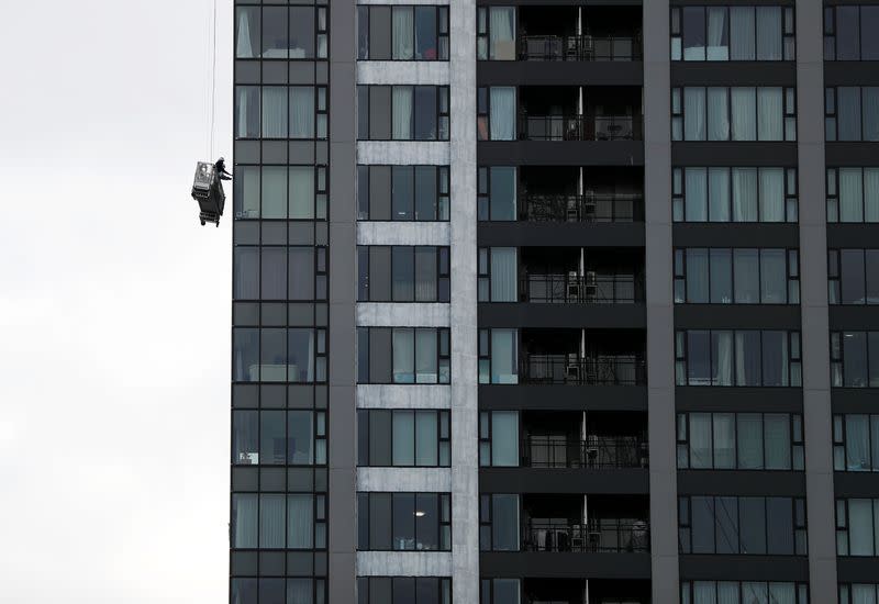 Window cleaners are seen next to a high-rise apartment building in Tokyo