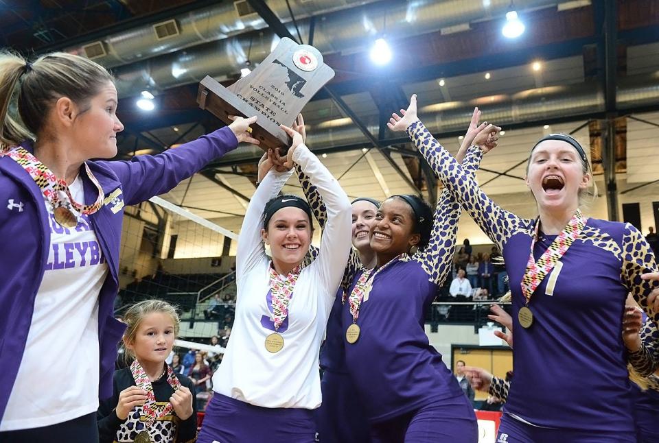 Smithsburg head coach Rachel Bachtell and several players raise the 2016 Maryland Class 1A state championship trophy at Ritchie Coliseum.