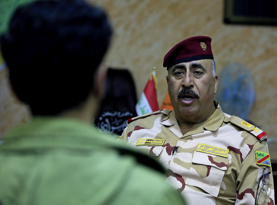 In this Monday, Nov. 12, 2018 photo, Gen. Qassim Mohamed, commander of Iraqi forces in the Qaim area speaks with The Associated Press in Qaim, Anbar province, Iraq. More than a year after this Iraqi town was freed from the Islamic State group, booms from airstrikes still echo and columns of smoke are visible, rising beyond the earthen berms and concrete walls marking the border with Syria. On the other side, the fight is raging to capture one of the militant group’s last enclaves. (AP Photo/Hadi Mizban)