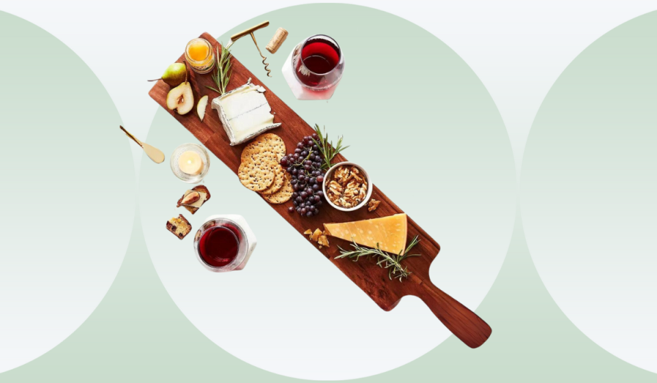 28-inch long cheese board filled with cheese, fruit, crackers and wine
