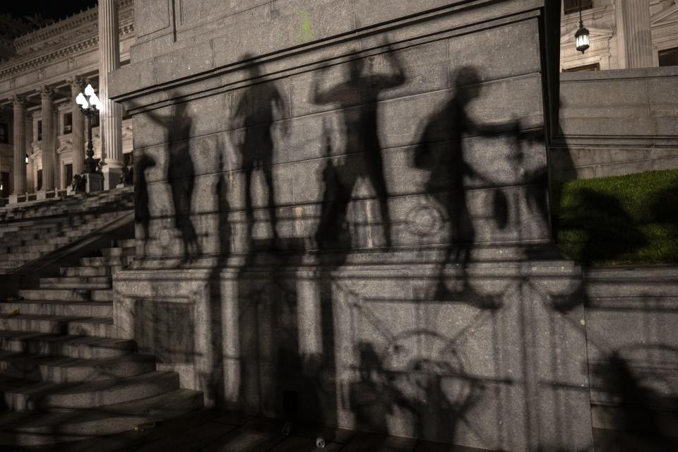 Las sombras, proyectadas en una pared, de manifestantes que protestan contra las medidas económicas del nuevo gobierno, en el Congreso Nacional, en Buenos Aires, el 21 de diciembre de 2023. (Foto AP/Rodrigo Abd)