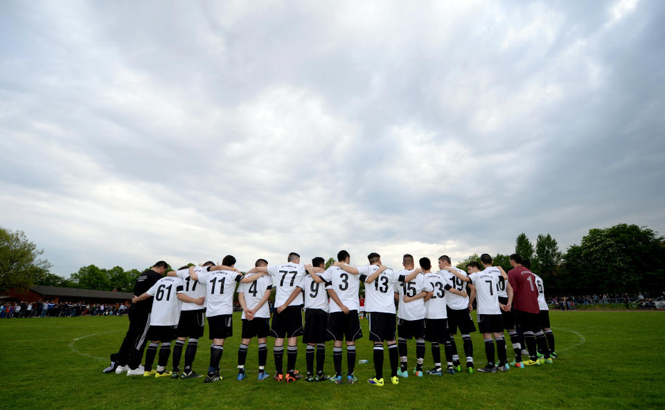 In this picture taken Wednesday, April 30, 2014, the soccer team of 17-year old German exchange student Diren Dede SC Teutonia 1910 holds a minute of silence prior to a soccer match in Hamburg, northern Germany. The father of the student who was killed in the United States criticized the country’s gun laws upon his arrival in Montana where his son was fatally shot. Celal Dede told the German news agency dpa Thursday that “America cannot continue to play the cowboy.” (AP Photo/dpa, Daniel Reinhardt)