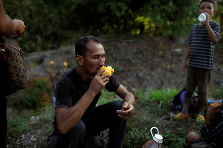 A Honduran migrant eats a mango as breakfast during a break in their journey towards the United States, in Mapastepec, Mexico April 20, 2019. REUTERS/Jose Cabezas