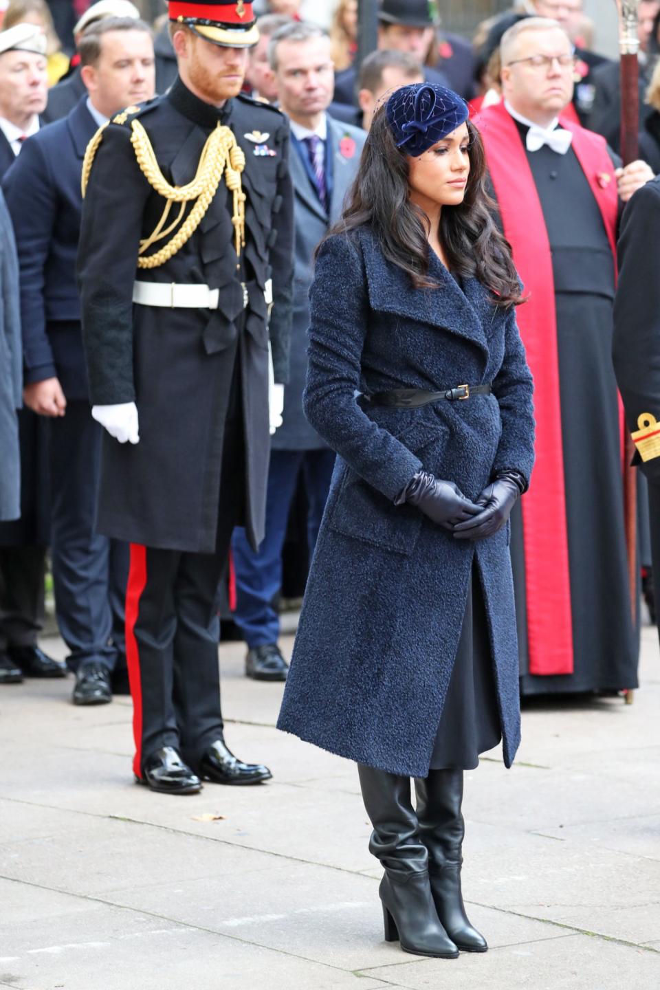 Meghan bundled up in a navy teddy coat while paying tribute to fallen soldiers at the the Field of Remembrance at Westminster Abbey. She topped off the look with a chic fascinator by Philip Treacy.
