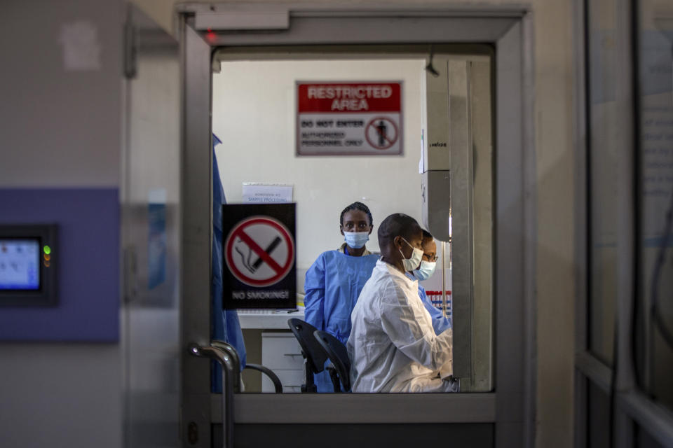 Medical personnel work testing patient samples for COVID-19 at the Rwanda Biomedical Center in the capital Kigali, Rwanda, Tuesday, July 28, 2020. Like many countries, Rwanda is finding it impossible to test each of its citizens for the coronavirus amid shortages of supplies but researchers there have created an innovative approach using an algorithm to refine the process of pooled testing that's drawing attention beyond the African continent. (AP Photo)