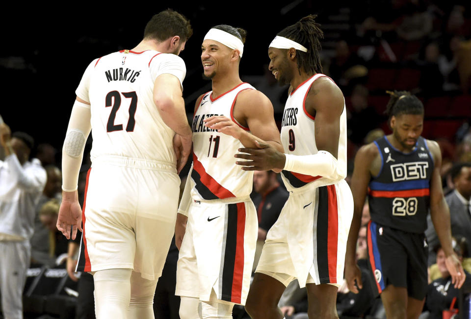 Portland Trail Blazers center Jusuf Nurkic, left, guard Josh Hart, center, and forward Jerami Grant, right, react after Grant scored during the second half of an NBA basketball game against the Detroit Pistons, in Portland, Ore., Monday, Jan. 2, 2023. (AP Photo/Steve Dykes)