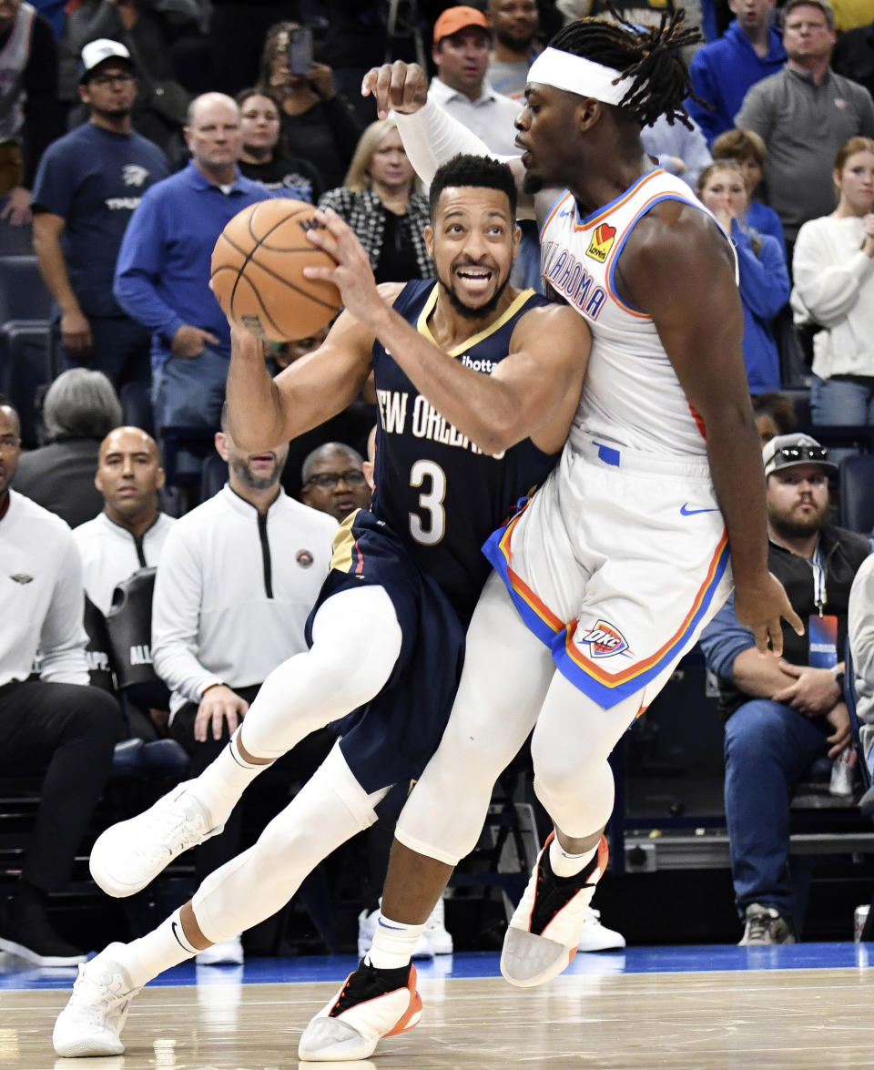 New Orleans Pelicans guard CJ McCollum, left, pushes past Oklahoma City Thunder guard Luguentz Dort, right, in the second half of an NBA basketball game, Wednesday, Nov. 1, 2023, in Oklahoma City. (AP Photo/Kyle Phillips)
