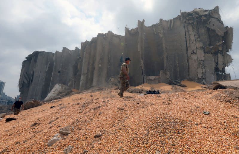 Lebanese army members walk near the damaged grain silo at the site of Tuesday's blast, at Beirut's port area