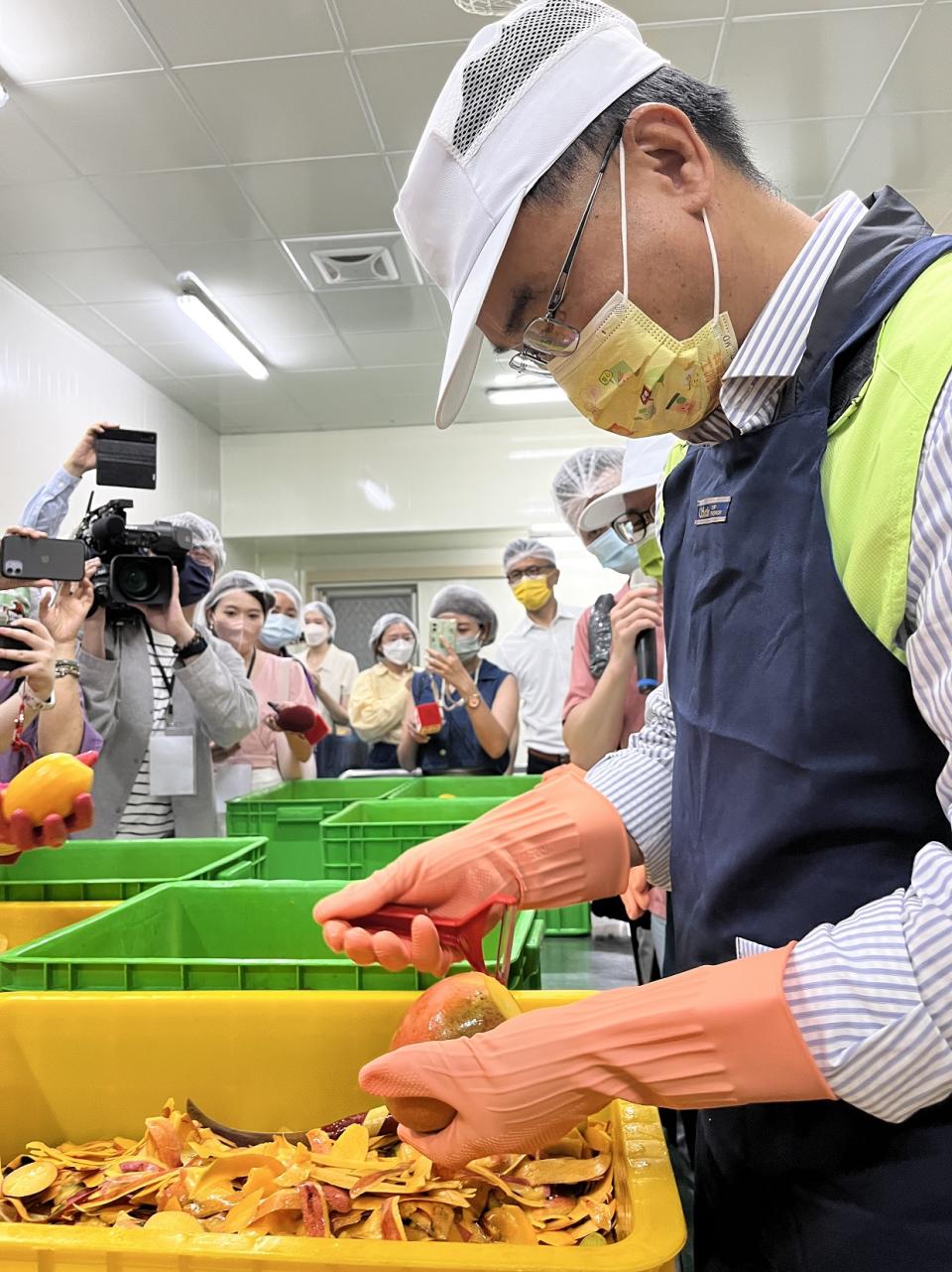 農委會主委陳吉仲嘗試製作芒果乾、試削芒果皮。（攝影／游昇俯）