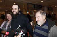 Canadian Greenpeace activist Alexandre Paul (C) smiles as he meets the media with his parents Raymond and Nicole after arriving at Montreal's airport, December 27, 2013. Paul was detained in Russia for more than three months following a protest against Arctic oil drilling in international waters. REUTERS/Christinne Muschi (CANADA - Tags: CIVIL UNREST CRIME LAW ENVIRONMENT)