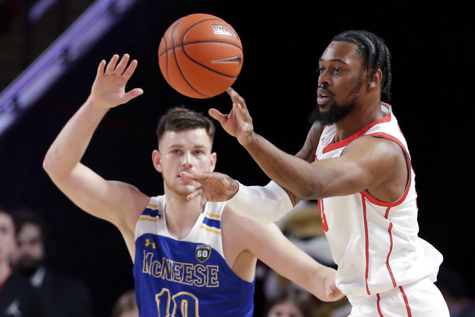 Houston forward J'Wan Roberts, right, passes the ball in front of McNeese State forward Roberts Berze, left, during the first half of an NCAA college basketball game Wednesday, Dec. 21, 2022, in Houston. (AP Photo/Michael Wyke)